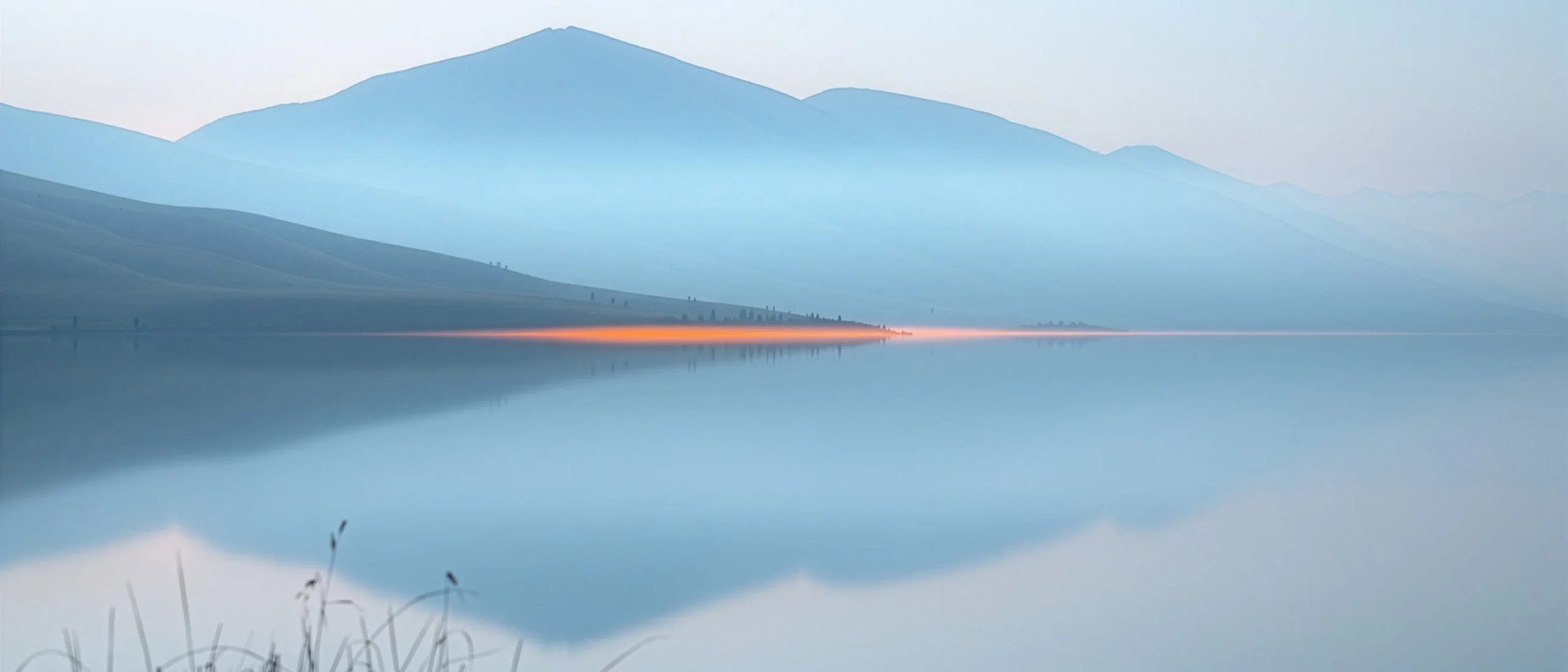 Alpine foothills lake in the evening, mountains in silhouette